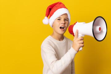 portrait of a little boy wearing a christmas hat and screaming by megaphone