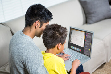 Biracial boy with father using laptop for video call, with class on screen - Powered by Adobe