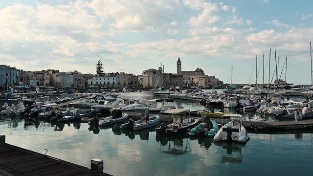 Trani, Puglia, Italy. August 2021. Pan footage of the port, on the left the cathedral of Trani. Beautiful summer day.
