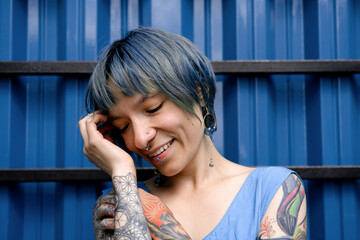Beautiful young woman with short blue hair on a blue background lifestyle portrait.