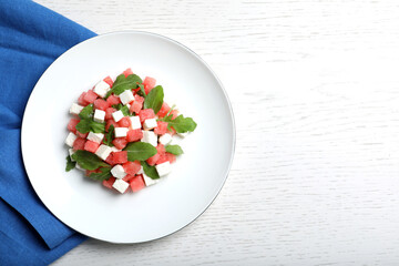 Delicious salad with watermelon, arugula and feta cheese on white wooden table, flat lay. Space for text