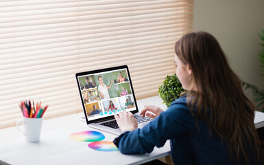 Fototapeta na wymiar Caucasian woman using laptop for video call, with diverse elementary school pupils on screen