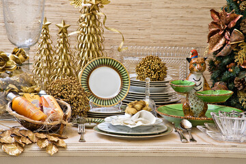 Mesa para o natal com uma decoração dourada com pequenas árvores de natal, pratos uma onça de...