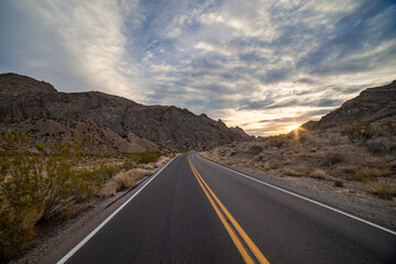 Driving down an empty road through the desert mountains