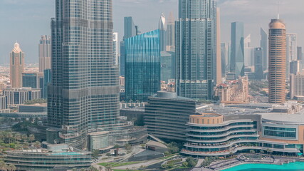 Skyscrapers rising above Dubai downtown timelapse, mall and fountain surrounded by modern buildings aerial top view