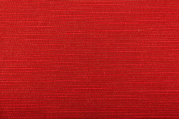 Fototapeta premium Factory fabric of red color . Close-up long and wide texture of natural red fabric. Fabric texture of natural cotton or linen textile material. Red canvas background