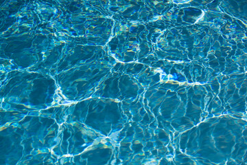 Obraz premium Background of blue water in swimming pool with sun reflection, ripple water wave in pool. Clear water background.