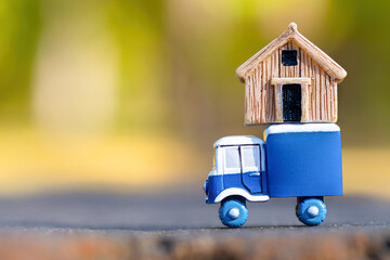 Toy truck with a tiny house on top - obrazy, fototapety, plakaty