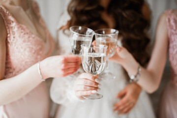 Photo bride with her friends drinking champagne from glasses
