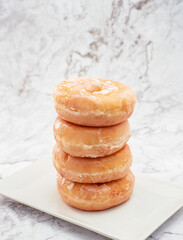 donuts de azucar y colorines rosas encima de una mesa de marmol