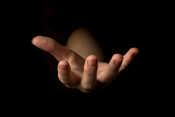 Hand gesture on a black background, palm up holding something, mockup and template for presentation...