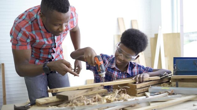 Close up of parenthood daddy teacher teach son professional using screwdriver and occupation brunettes touch wood hold hand equipment craftsman.