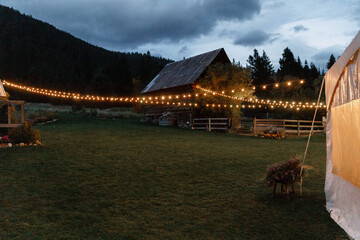 Twinkling party lights decorating String lights a wedding reception Evening wedding ceremony Farm...
