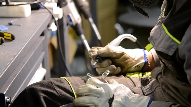 Worker grinding metal detail close-up. Person in working gloves manually