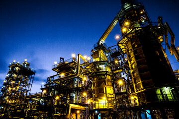 Pipes and buildings of refinery - big modern factory with lights