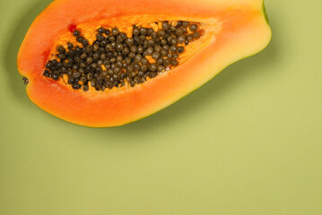 Papaya fruit on a green background. Half papaya.