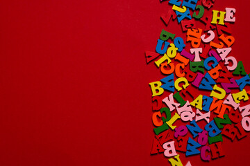 Random colorful alphabet on a red background, colorful letters.