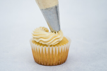 vanilla cupcake decorated with piping bag white vanilla cream 