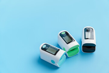 Three Pulse Oximeter devices on a blue background