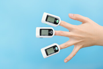 Fear of coronavirus, three pulse oximeters on a woman's palm.