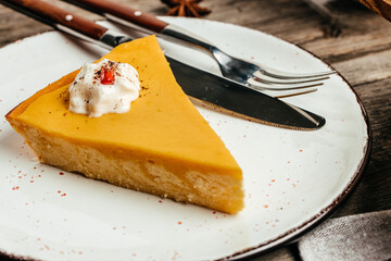Plate with slices of pumpkin cheesecake with whipped cream, top view