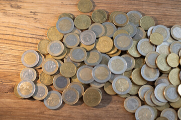 Euro coins of different countries lie on top of each other on a wooden table Cents from Europe
