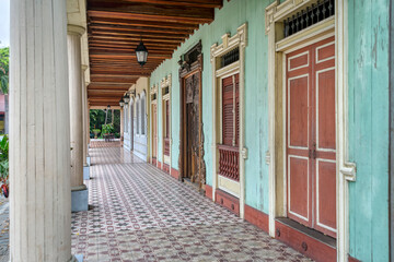 Guayaquil, Guayas, Ecuador - November, 2013: Exterior hallway leading to several doors of a 19th century old house, at the Parque Nacional (National Park).