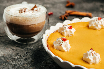 Homemade pumpkin pie cheesecake decorated with whipped cream and latte. Food recipe background. Close up