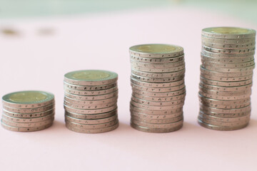 Euro coins in a stack Financial profit uphill on a pink background Cash income