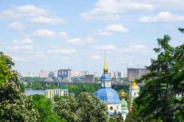 Fototapeta na wymiar Landscape overlooking a Christian church in the city of Kiev. Spring day. Blue sky with small white clouds. High quality photo