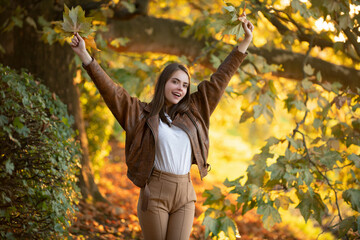 Beautiful girl enjoying autumn. Portrait of Young Woman Outdoor on Autumn Background.