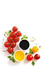 Various spices, tomatoes, olive oil and balsamic vinegar on a white background top view. Free space for text. Food background, ingredients for cooking.