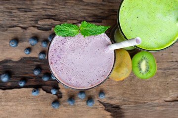 Blueberry smoothie purple colorful fruit juice milkshake blend beverage healthy high protein the taste yummy In glass drink episode morning on wooden background.