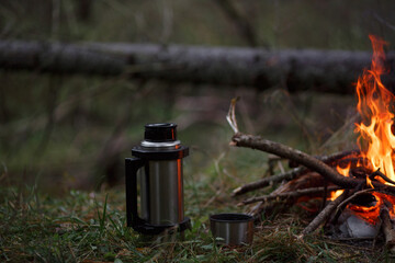 Fototapeta premium Thermos with a mug by the fire.