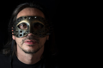 Close up of a man wearing Halloween mask on black background. Soft focus
