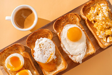 fried Toast bread with four different types of cooked chicken eggs, scrambled eggs, fried eggs, poached egg and creamed egg. Breakfast of chicken eggs. methods of making eggs for breakfast