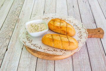Rolls baked with olive oil with garlic sauce with oregano and pepper on wooden board