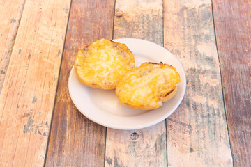Half a roll with garlic cream and cheese gratin in the stone oven
