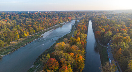 Aerial views of autumn in Munich. Isar river seen from above with colorful trees nearby - obrazy, fototapety, plakaty