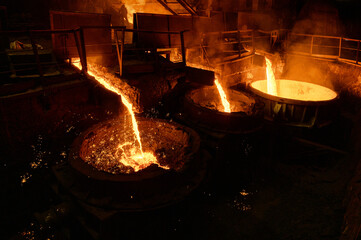 Blast furnace slag and pig iron tapping. Molten metal and slag are poured into a ladle.
