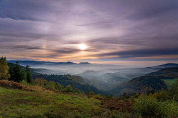 Fototapeta na wymiar Dreamlike autumn sunset with a 22° halo and two sun dogs over the Murgtal in the northern Black Forest