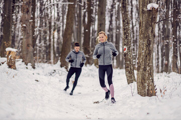 Happy couple racing in nature at snowy winter day. Fun, healthy life, relationship