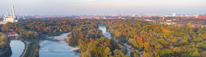 Aerial views of autumn in Munich. Isar river seen from above with colorful trees nearby