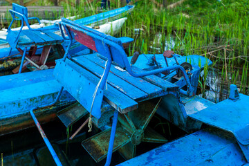 Photo of old wooden blue catamarans on the water