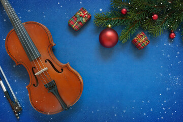 Old violin and fir-tree branches with Christmas decor. Christmas, New Year's concept. Top view, close-up.