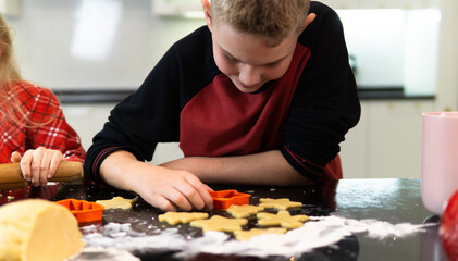 An 11-year-old boy cooks homemade cookies at home. Homemade cookies in the kitchen. Cookies for Christmas and New Year. 