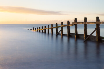 Obraz premium Long Exposure Beach Sunrise with Groyne