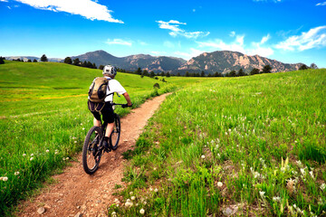 Mountain biker rides the Flatirons VIsta Trail near Boulder, Colorado - obrazy, fototapety, plakaty