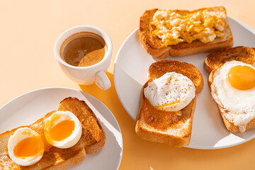 fried Toast bread with four different types of cooked chicken eggs, scrambled eggs, fried eggs, poached egg and creamed egg. Breakfast of chicken eggs. methods of making eggs for breakfast