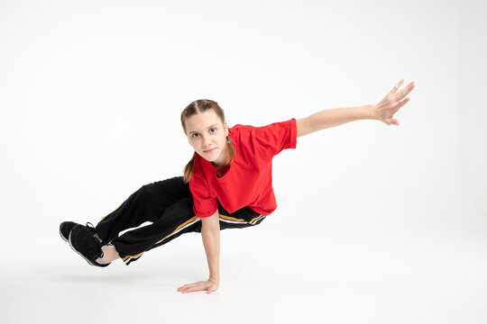 Isolated young Russian girl hip hop break dancer dancing on white studio background, performing back side one hand stand element of downrock breakdance